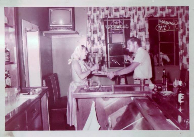 Sheldon Furber at the Dolphin bar receiving a huge glass of beer from a woman in a headscarf