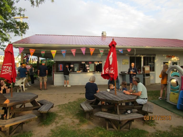 Hots Point Building: walk-up ice cream stand with pennant flags, red umbrellas and people at picnic tables