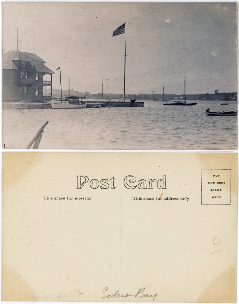 Front and back of a photo postcard: a two-story clubhouse, flagpole and moored boats; back penciled 'Sodus Bay'