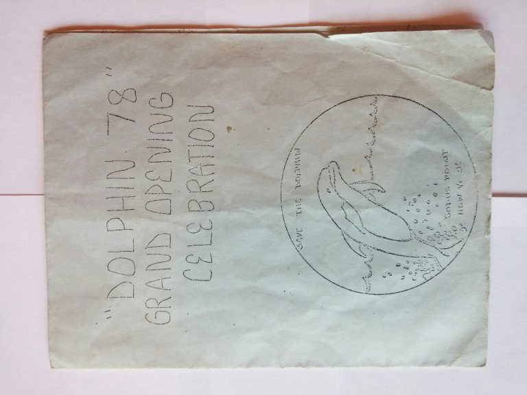 Hand-lettered 'Dolphin 78 Grand Opening Celebration' sheet with a circular dolphin drawing, shown sideways