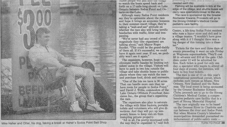 Newspaper article on the powerboat race, with a photo of a man and his dog resting by a parking sign